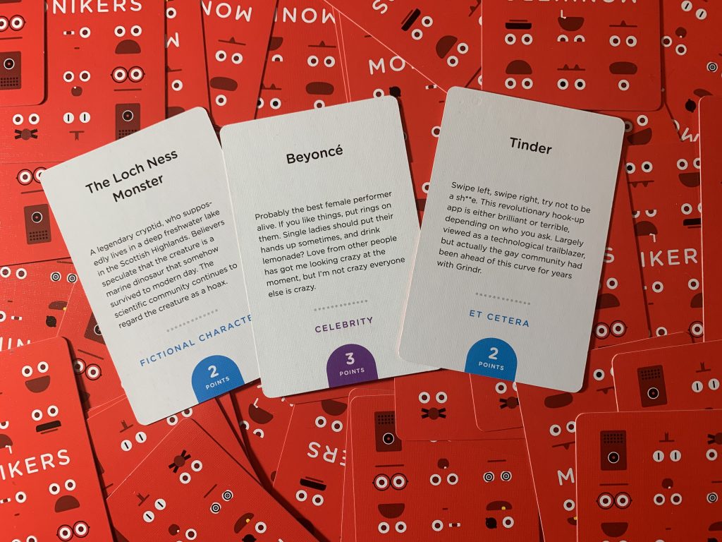 Photo showing three examples of prompt cards from the family card game Monikers: 'The Loch Ness Monster', 'Beyonce', and 'Tinder'.